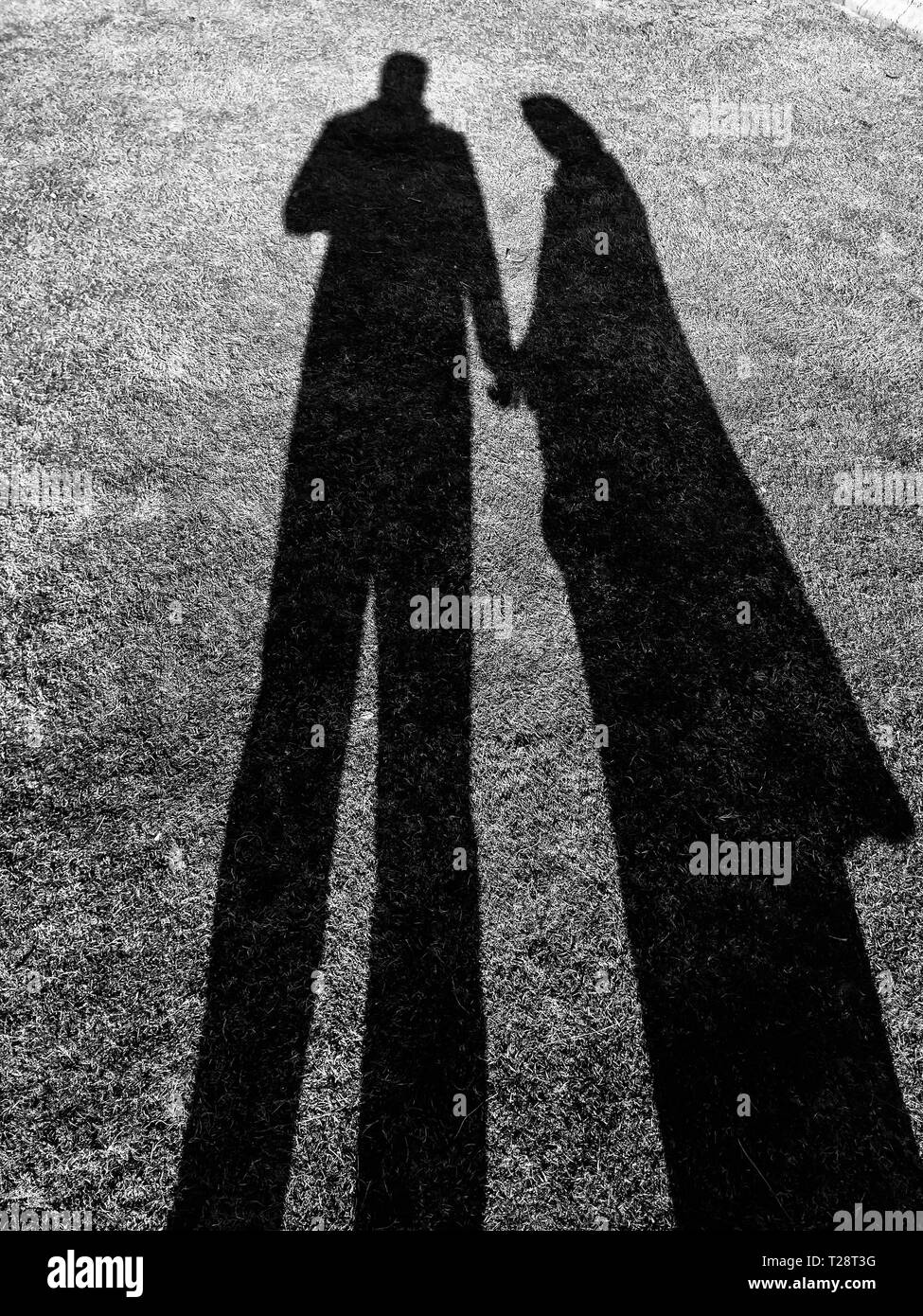 Schatten von Mann und Frau in Liebe Hände halten in einem Garten. Stockfoto