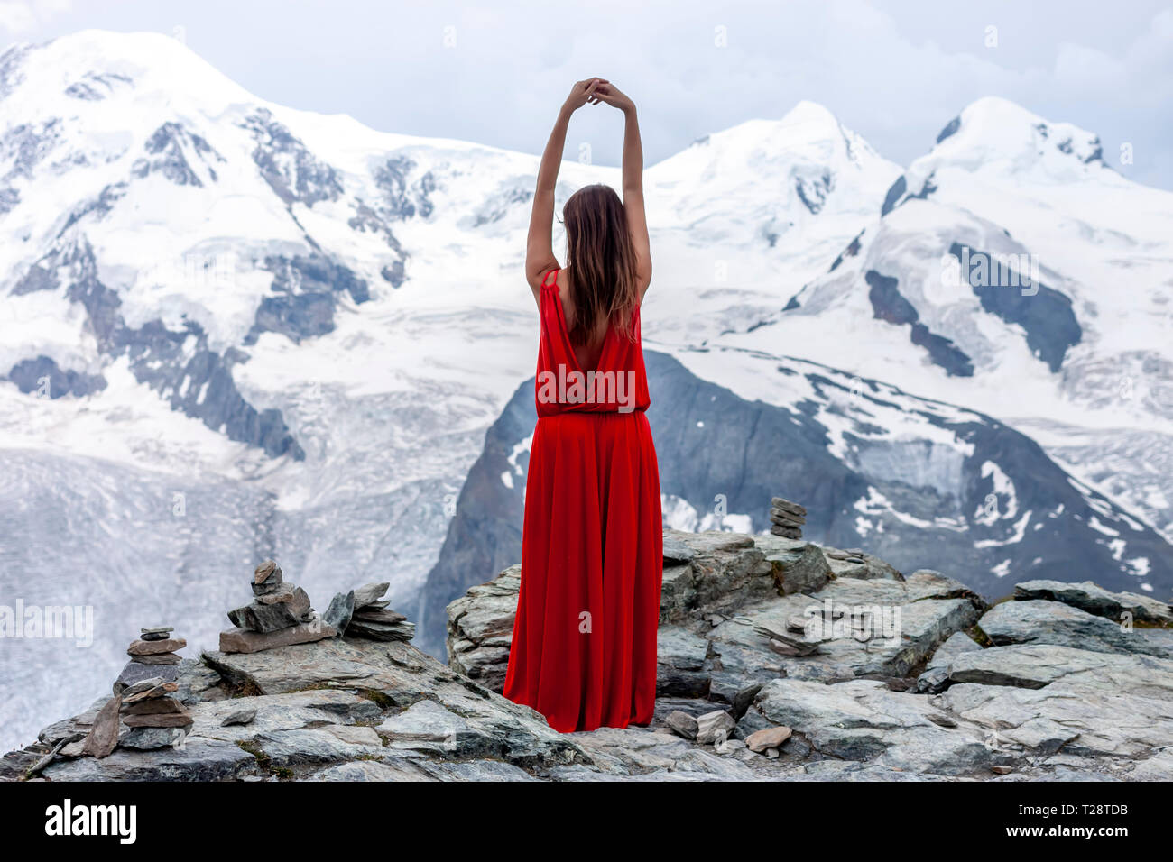 Frau in langen roten Kleid auf dem Hintergrund der Gletscher Stockfoto