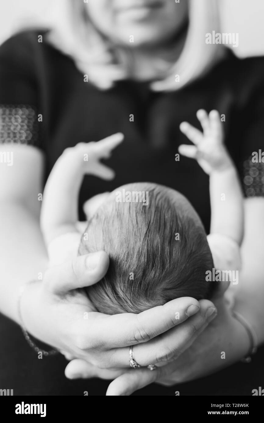 Halten Sie den Kopf der Mutter ihr neugeborenes Baby in Händen Stockfoto