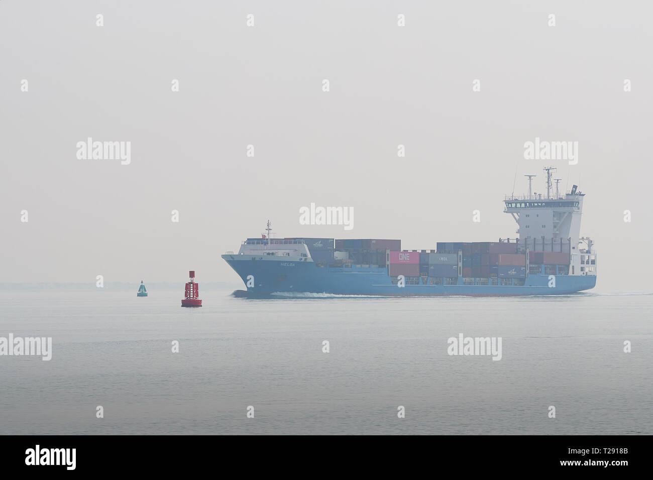 Die kleine Containerschiff, Helga, Verlassen, eine Bank der frühen Morgen Meer Nebel, wie sie in den Hafen von Southampton tiefe Wasser Kanal, UK. 28. März 2019. Stockfoto