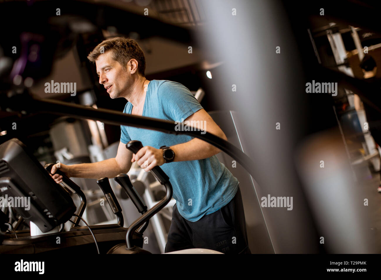 Junger Mann, Übung, die auf elliptischen Cross Trainer im Sport Fitness Gym Club Stockfoto