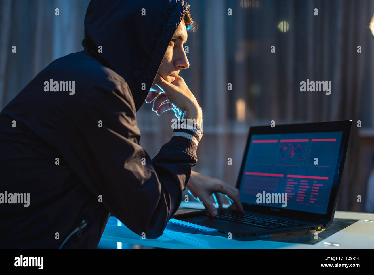 Eine männliche Hacker in der Haube Nachdenken über das Problem der Hacking und Diebstahl von Access Datenbanken mit Passwörtern. Das Konzept der Cybersicherheit Stockfoto