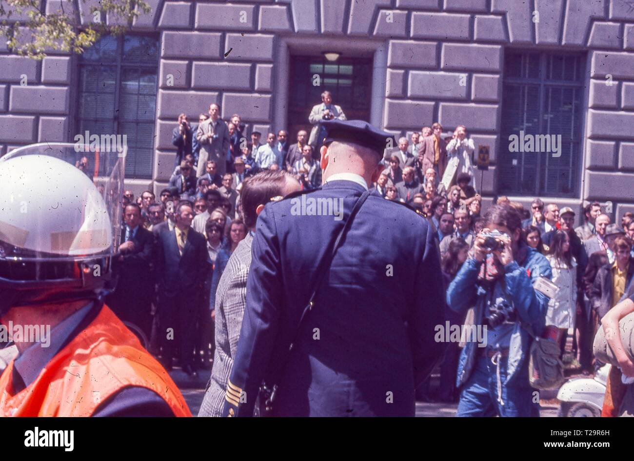 Während der 1971 Tag der Proteste gegen den Vietnamkrieg, eine große Gruppe von professionell gekleidete Menschen, wahrscheinlich aufhalten und Beschäftigte im öffentlichen Dienst, stehen außerhalb der Internal Revenue Service Gebäude, mit DC Metropolitanpolizei-abteilung Chief Jerry V Wilson sichtbar, in Washington, DC, Mai 1971. () Stockfoto