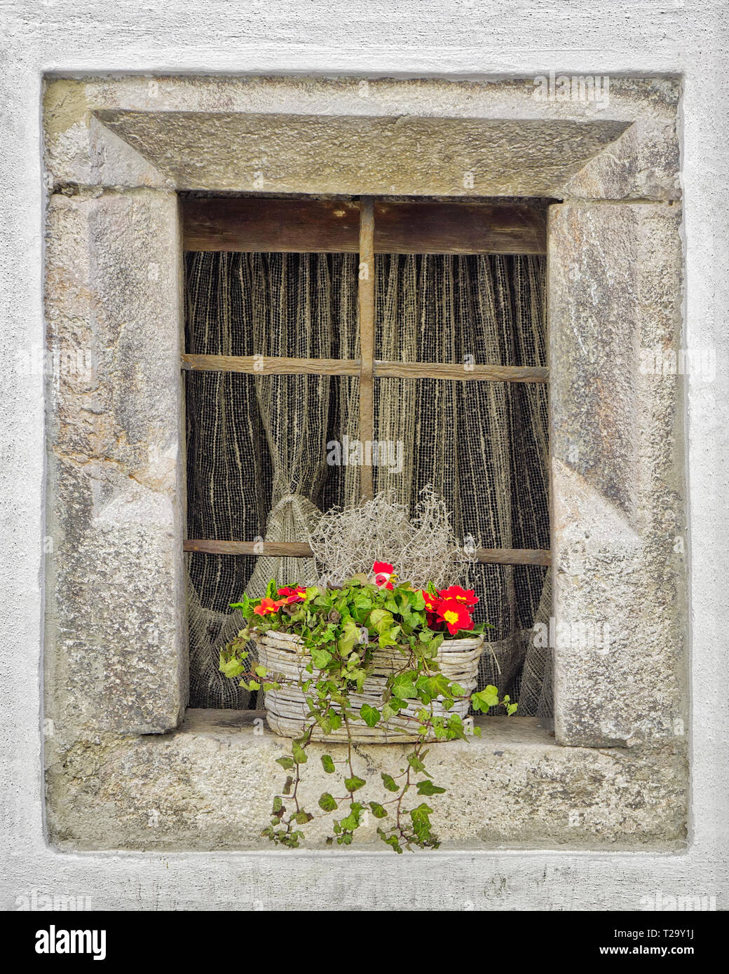 AT - Tirol: alte Stein Fenster mit Blumenkorb in Rattenberg am Inn Stockfoto