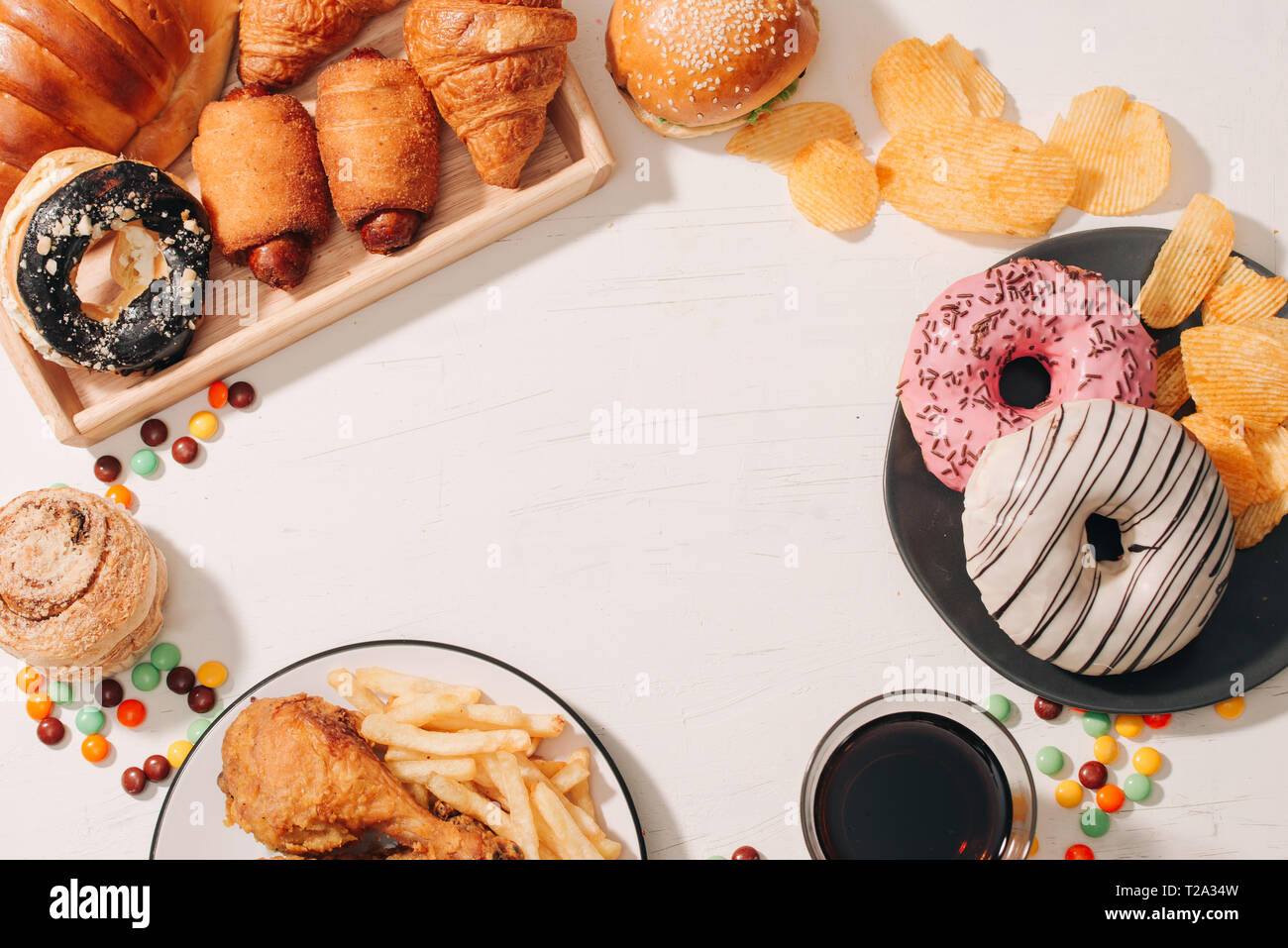 Fast Food und ungesundes Essen Konzept - in der Nähe von Fast-Food-Snacks und Cola trinken am weißen Tisch Stockfoto