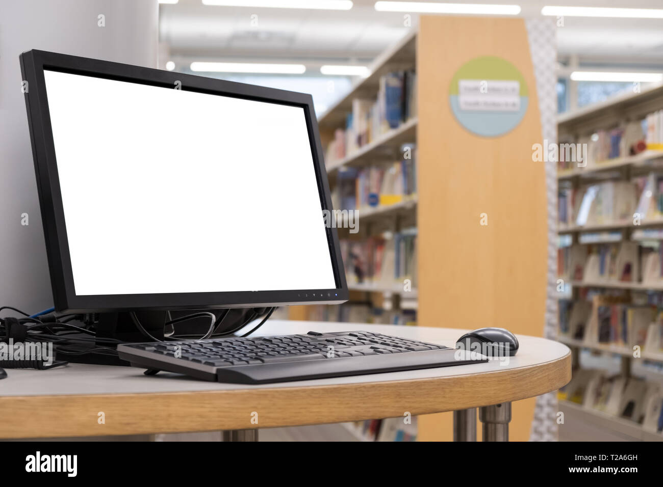 Computer mit leerer Bildschirm Monitor auf dem Tisch in der Bibliothek Stockfoto