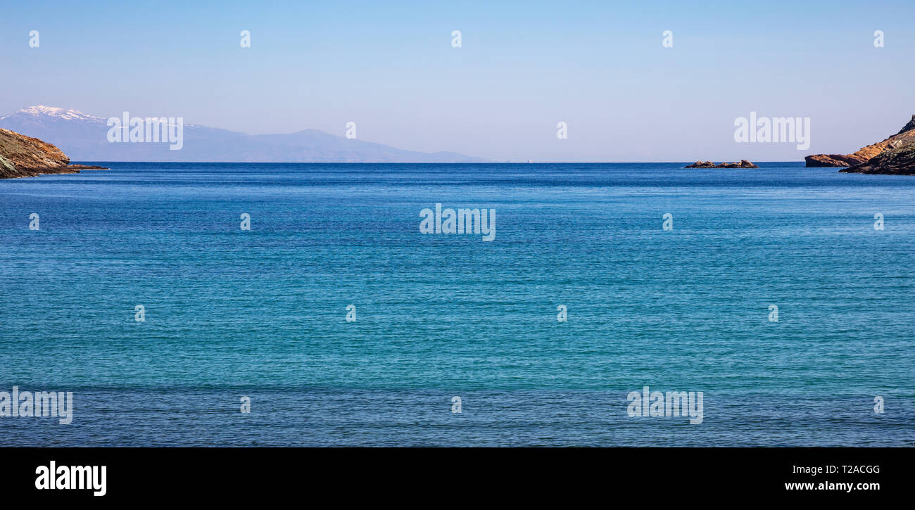 Griechenland. Ägäis. Blauer Himmel, ruhige türkisfarbene Meer Wasser und verschneiten Berge. Stockfoto