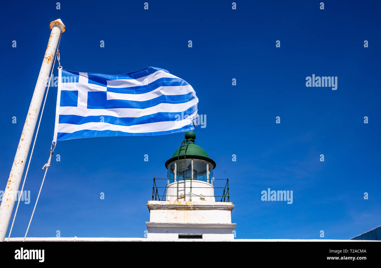 Griechenland. Kea Insel Leuchtturm. Griechische Flagge Schwenkten am klaren, blauen Himmel Hintergrund Stockfoto