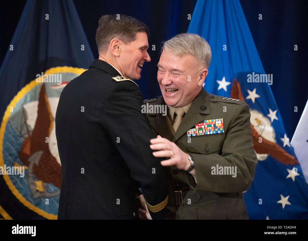 Der scheidende Kommandeur des US Central Command, General Joseph L. Votel, umfasst sein Ersatz Marine Corps Gen. Frank McKenzie, rechts, während seinen Ruhestand Festakt in Macdill Air Force Base, 29. März 2019 in Tampa, Florida. Votel im Ruhestand nach 39 Jahren Militärdienst. Stockfoto