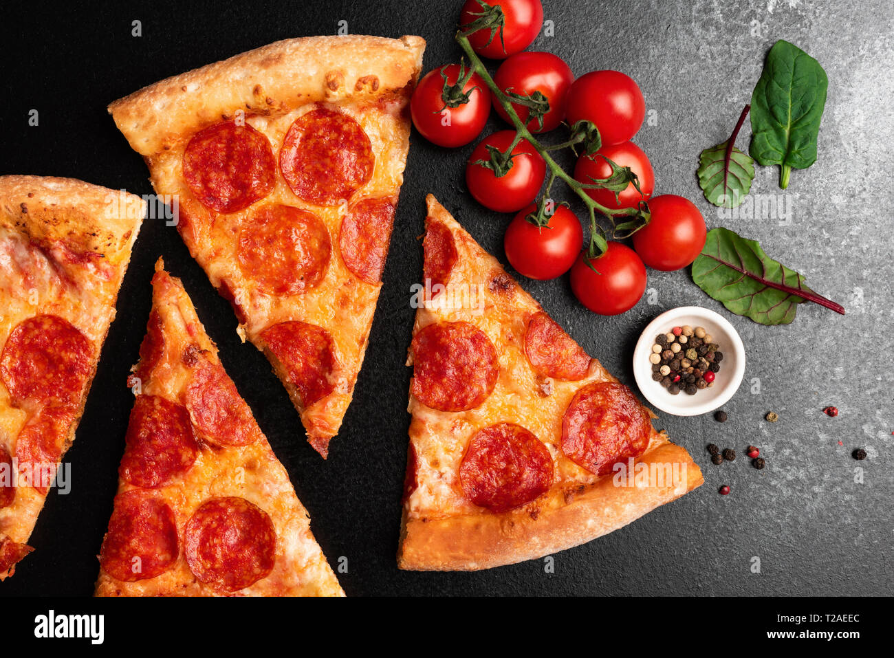 Pepperoni Pizza Slices auf schwarzen Hintergrund der Ansicht von oben, Nahaufnahme. Scheibe der leckere Pizza Stockfoto