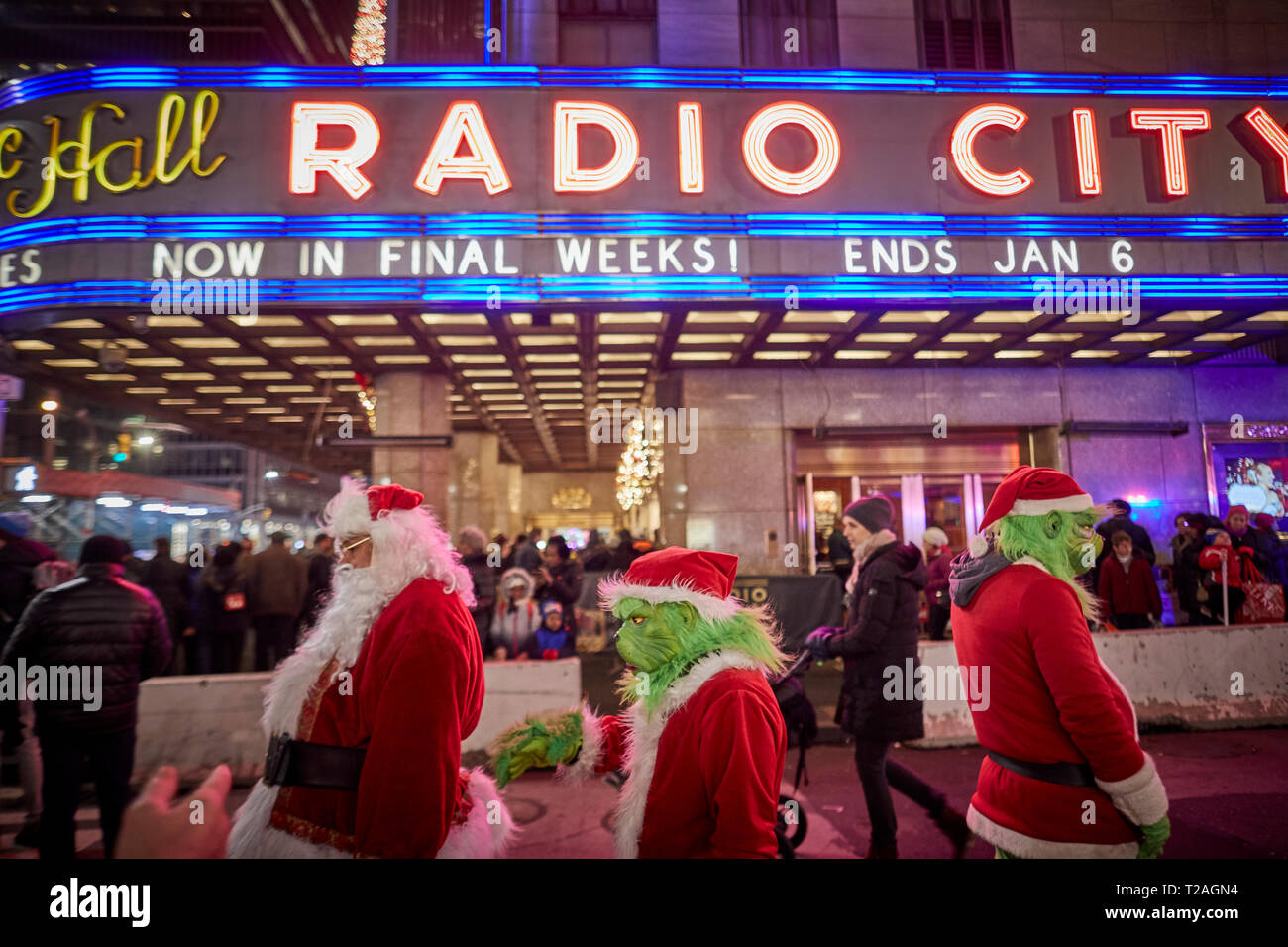 Weihnachtsschmuck Radio City Gaukler verkleidet als Weihnachtsmann und der Grinch auf der Suche nach Tipps, 6. Avenue, Manhattan, New York bei Nacht Stockfoto