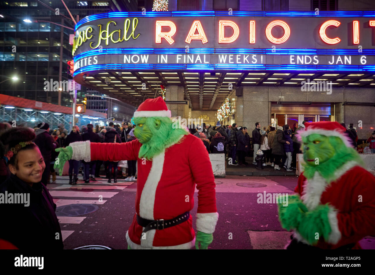 Weihnachtsschmuck Radio City Gaukler verkleidet als Weihnachtsmann und der Grinch auf der Suche nach Tipps, 6. Avenue, Manhattan, New York bei Nacht Stockfoto