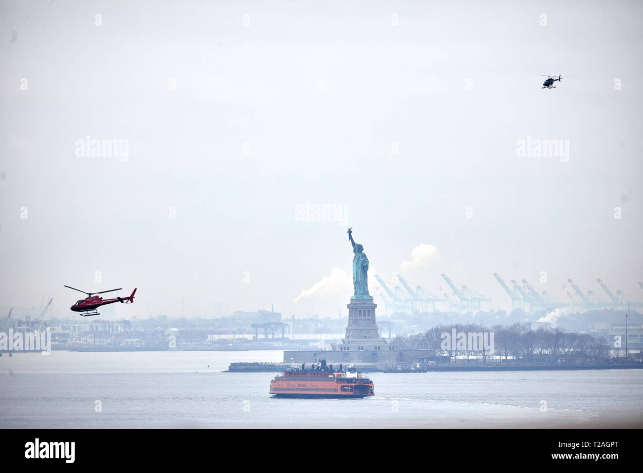 Sehenswürdigkeiten Freiheitsstatue und touristische Hubschrauber Ferienflügen von Manhattan, New York bei Nacht Stockfoto