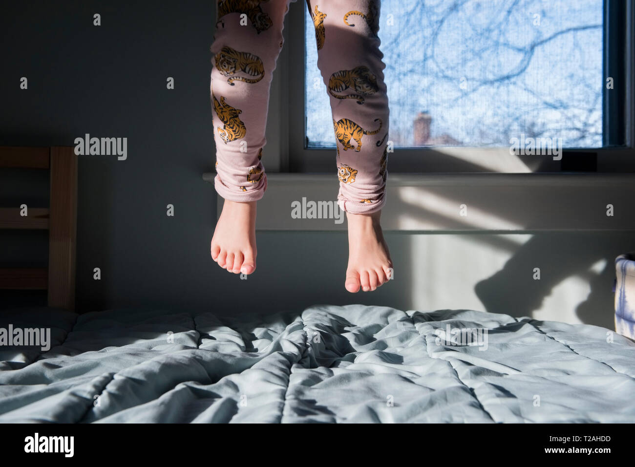 Beine der Mädchen auf dem Bett springen Stockfoto