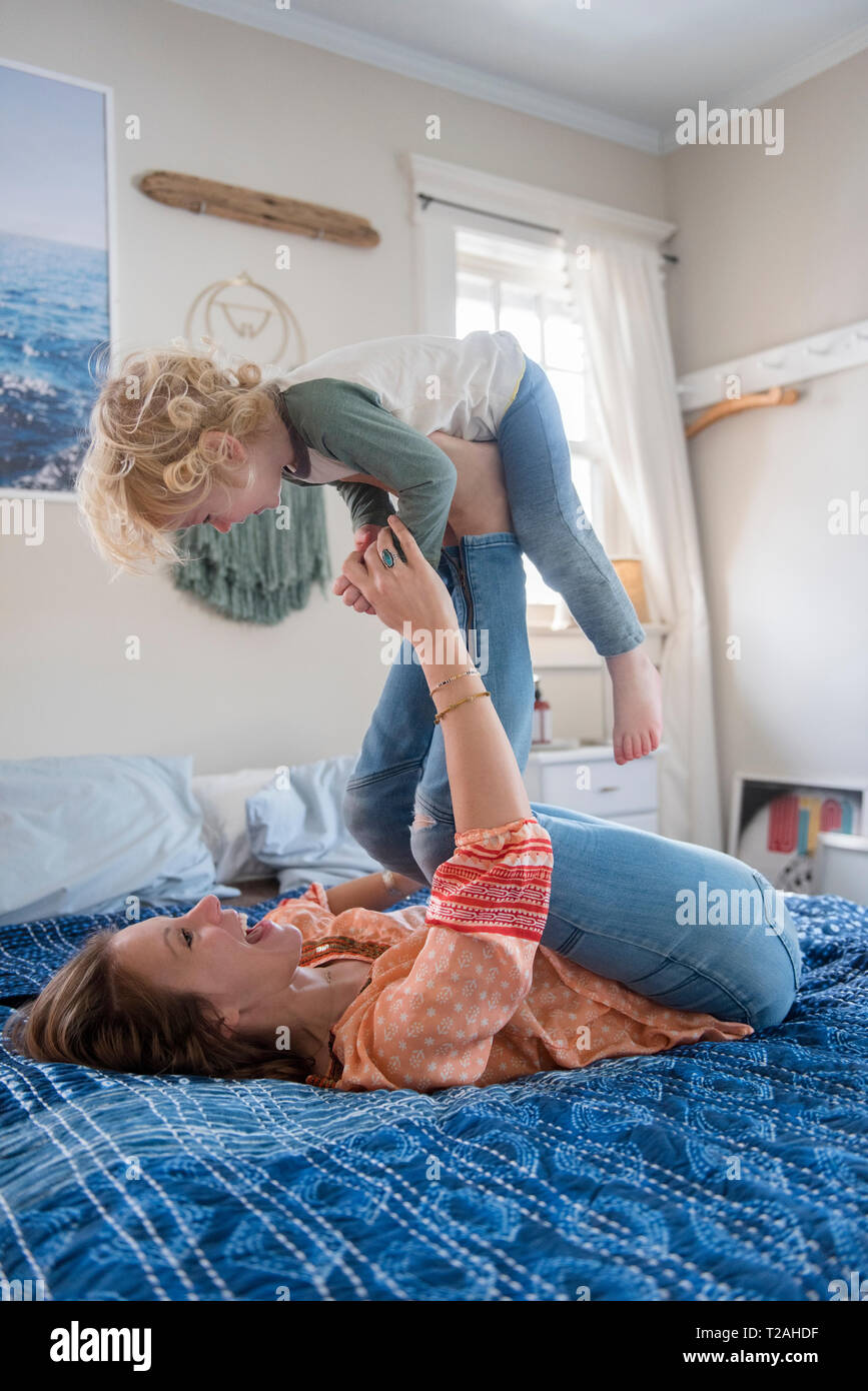 Frau spielen mit ihrem Sohn auf dem Bett Stockfoto