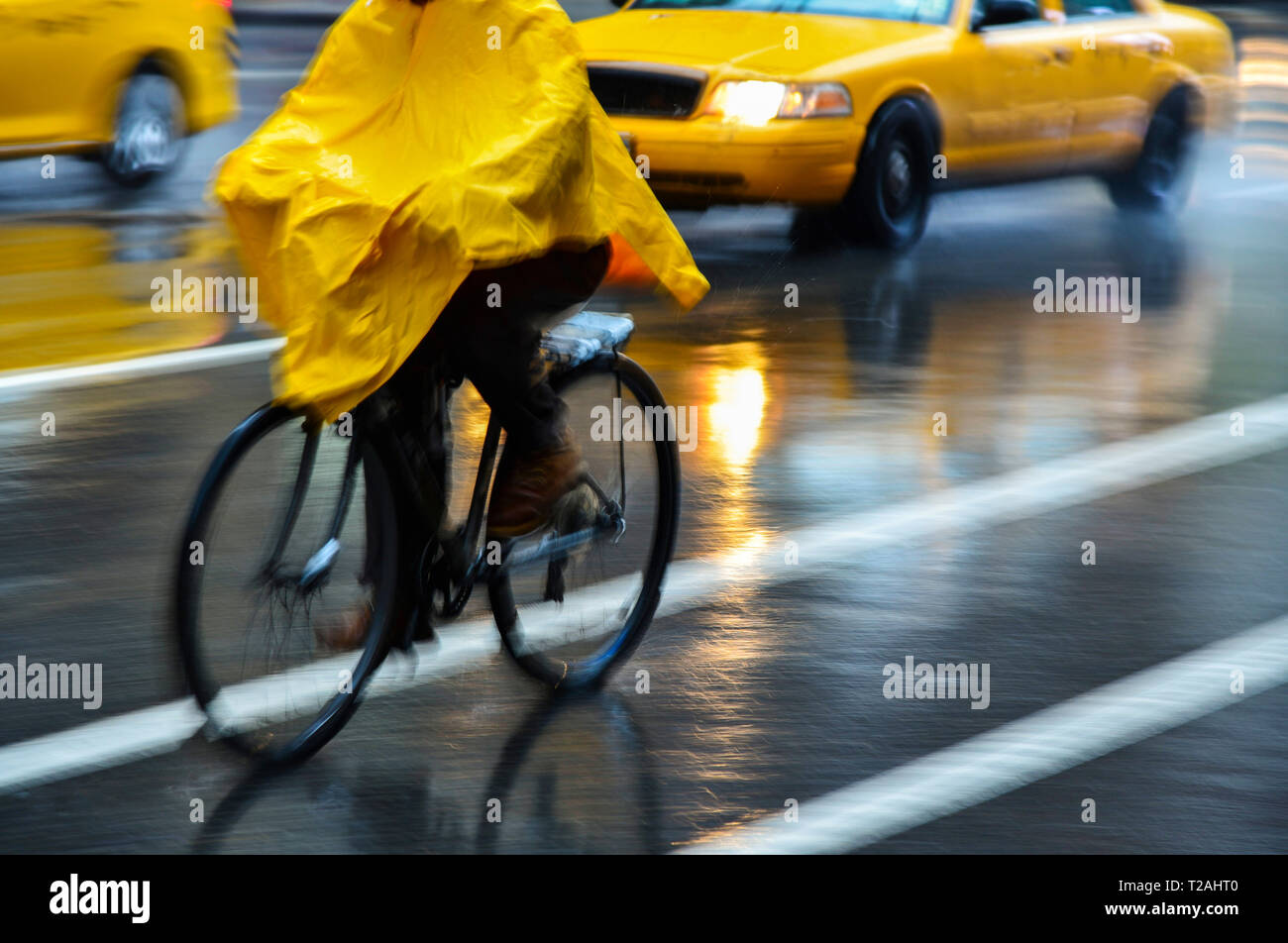Radfahrer in gelb Poncho bei Regen in New York City, USA Stockfoto