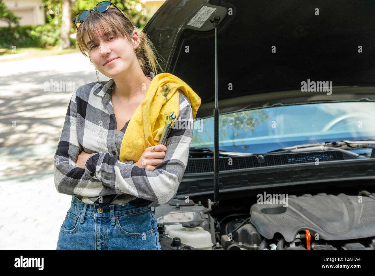 Frau mit Öl rag neben Auto Stockfoto