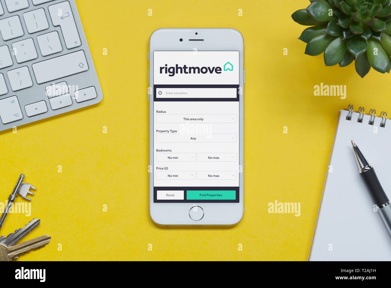 Ein iPhone zeigt die Rightmove website ruht auf einem gelben Hintergrund Tabelle mit einer Tastatur, Tasten, Notepad und Anlage (nur redaktionelle Nutzung). Stockfoto Ein iPhone zeigt die Rightmove website ruht auf einem gelben Hintergrund Tabelle mit einer Tastatur, Tasten, Notepad und Anlage (nur redaktionelle Nutzung). Stockfoto