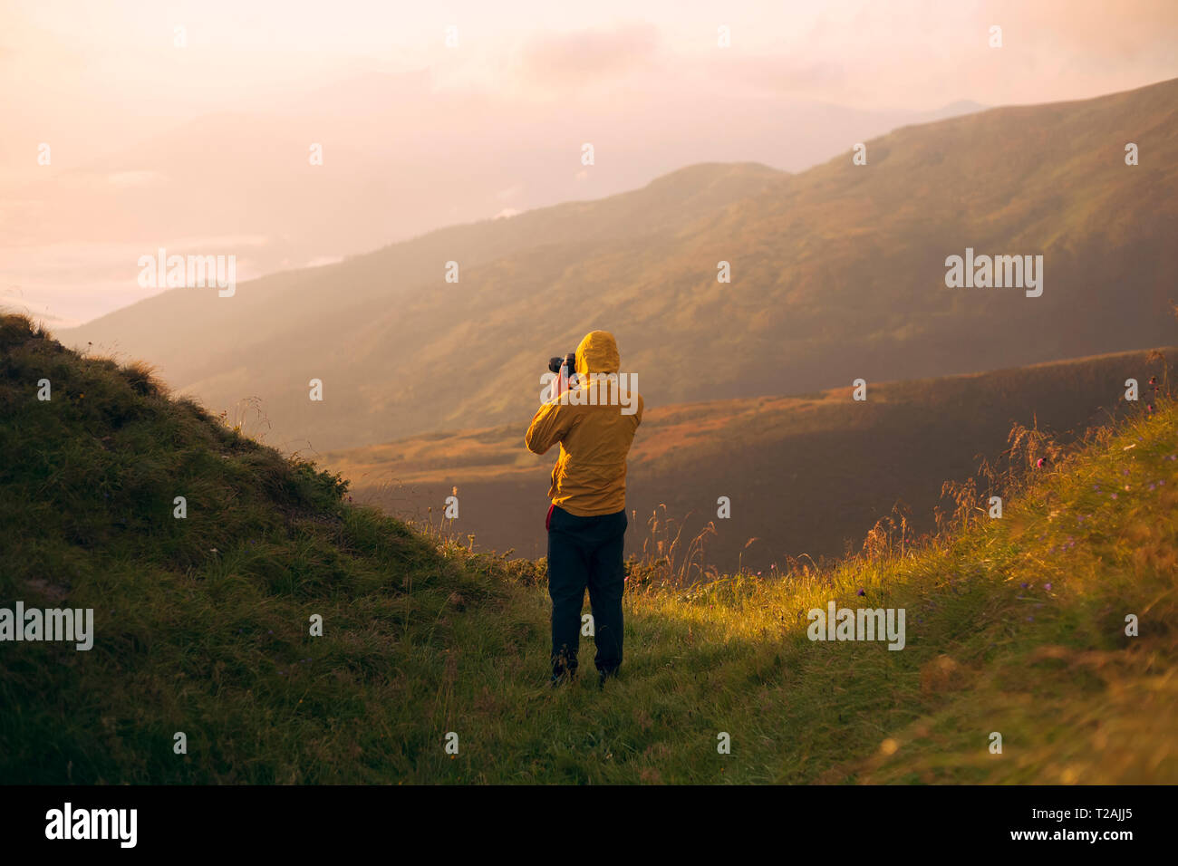Mann in der gelben Jacke Fotographien nehmen in den Karpaten Gebirge Stockfoto