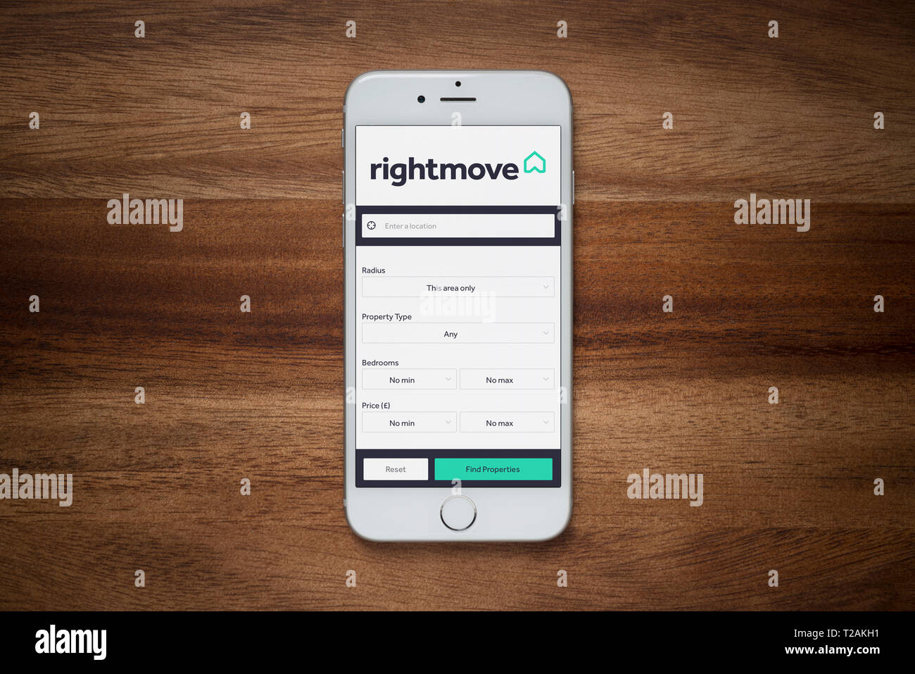Ein iPhone zeigt die Rightmove Website beruht auf einem einfachen Holztisch (nur redaktionelle Nutzung). Stockfoto Ein iPhone zeigt die Rightmove Website beruht auf einem einfachen Holztisch (nur redaktionelle Nutzung). Stockfoto