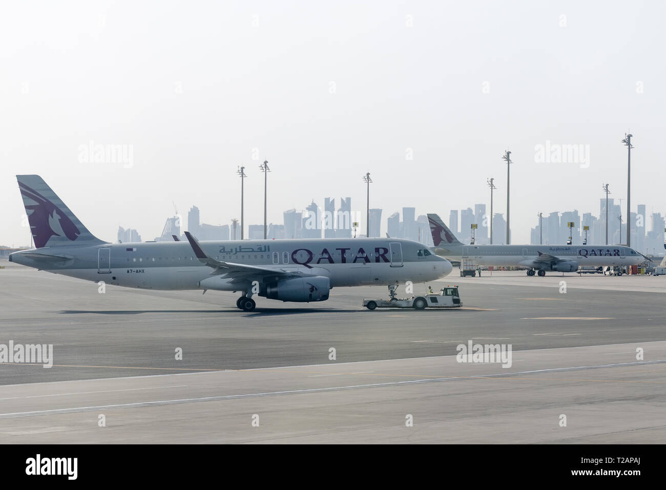 Doha, Katar, 2018-05-01: Abschleppen Katar Flugzeuge auf den Parkplatz von TUG Pushback Traktor. Ground Support Equipment am Flughafen. Stockfoto