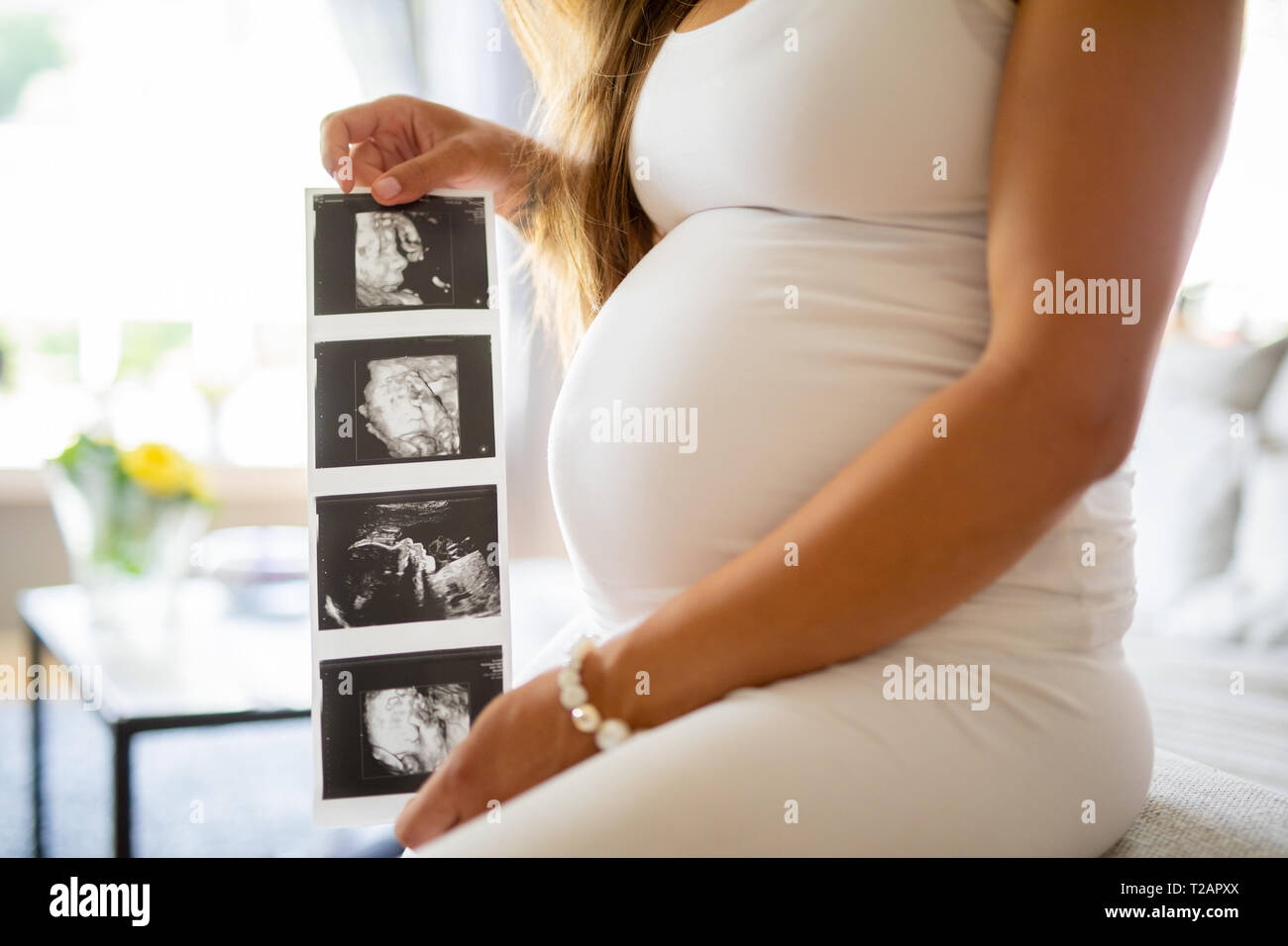 In der Nähe der schwangeren Frau hält Ultraschall Fotos in Ihrem Magen Stockfoto