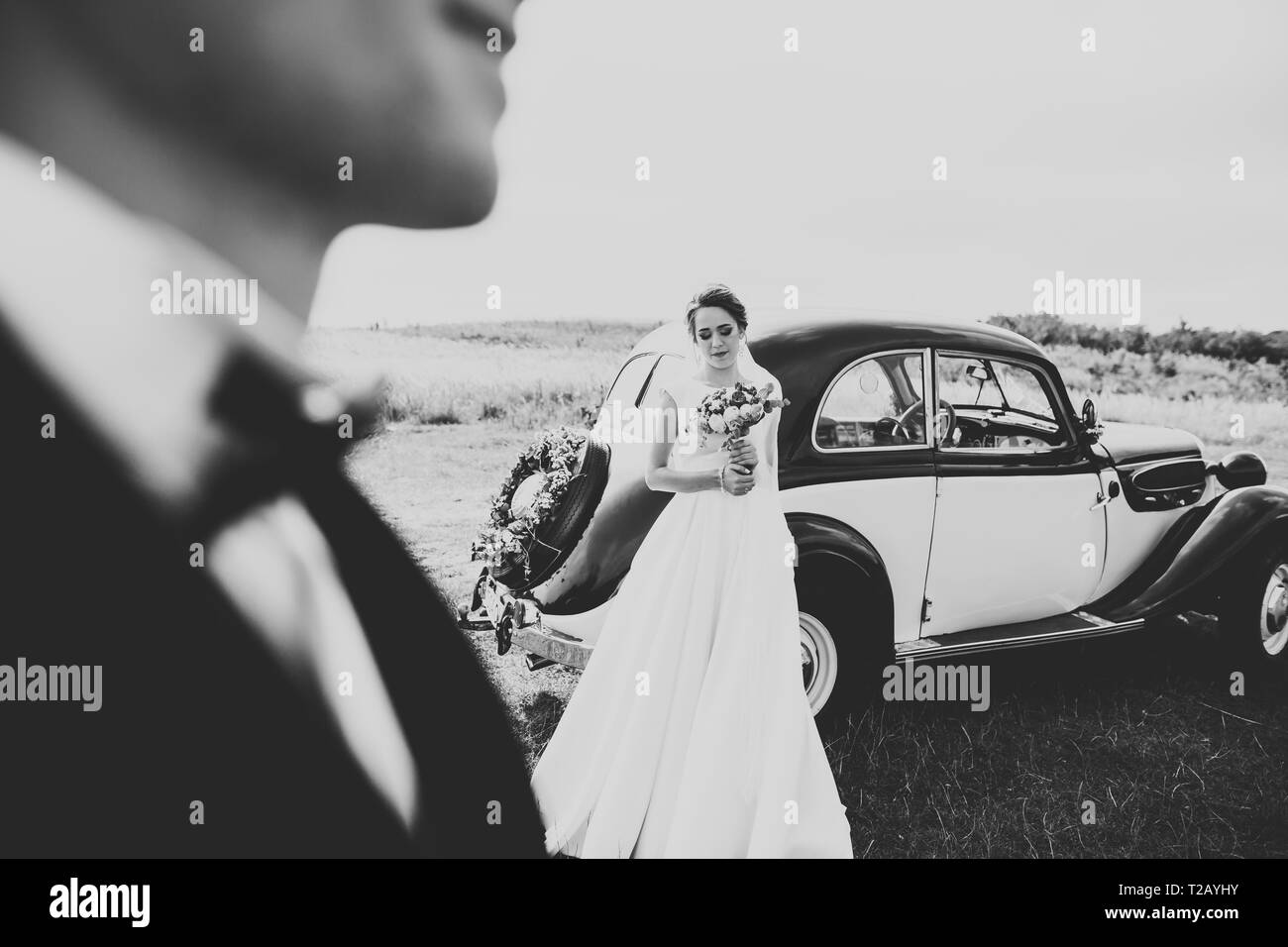 Happy jungvermählte Paar, Mann und Frau Küssen in der Nähe von eleganten retro Auto. Stockfoto