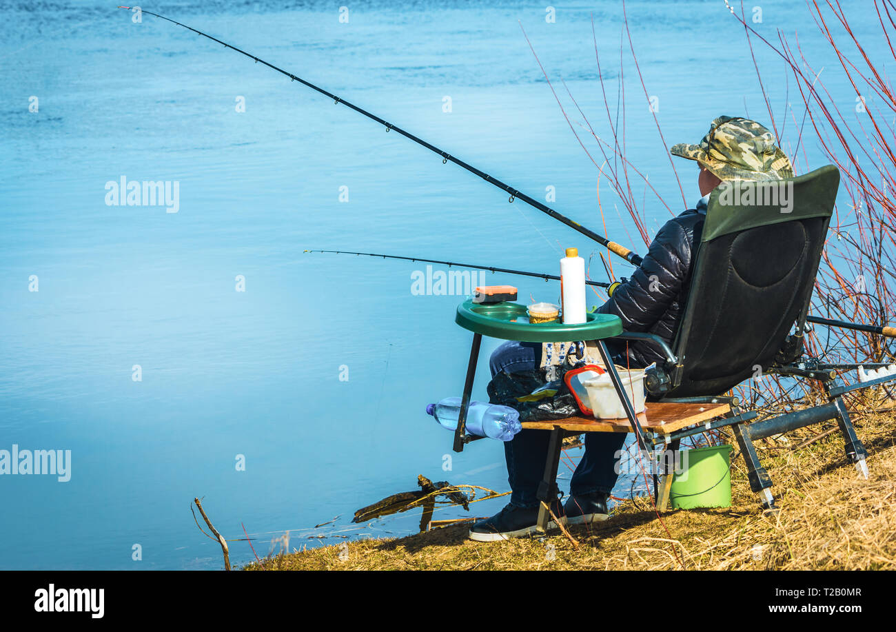 Fischer sitzt auf einem Stuhl am Strand mit Angeln und Fische  Stockfotografie - Alamy