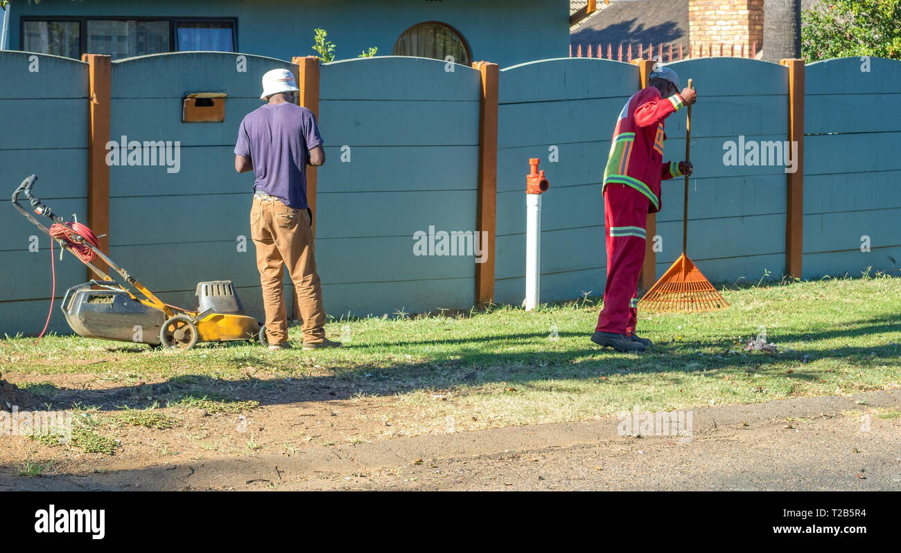 Johannesburg, Südafrika - Zwei nicht identifizierte schwarze Arbeiter beschäftigt mit Gelegenheitsarbeiten im häuslichen Garten Bild im Querformat. Stockfoto