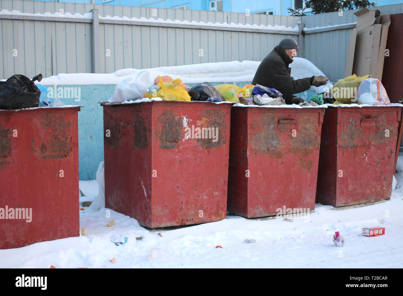 Ein Obdachloser, hungrigen und armen Mann auf der Suche nach Nahrung in Mülltonnen sammeln Abfall Arbeitslose Stockfoto