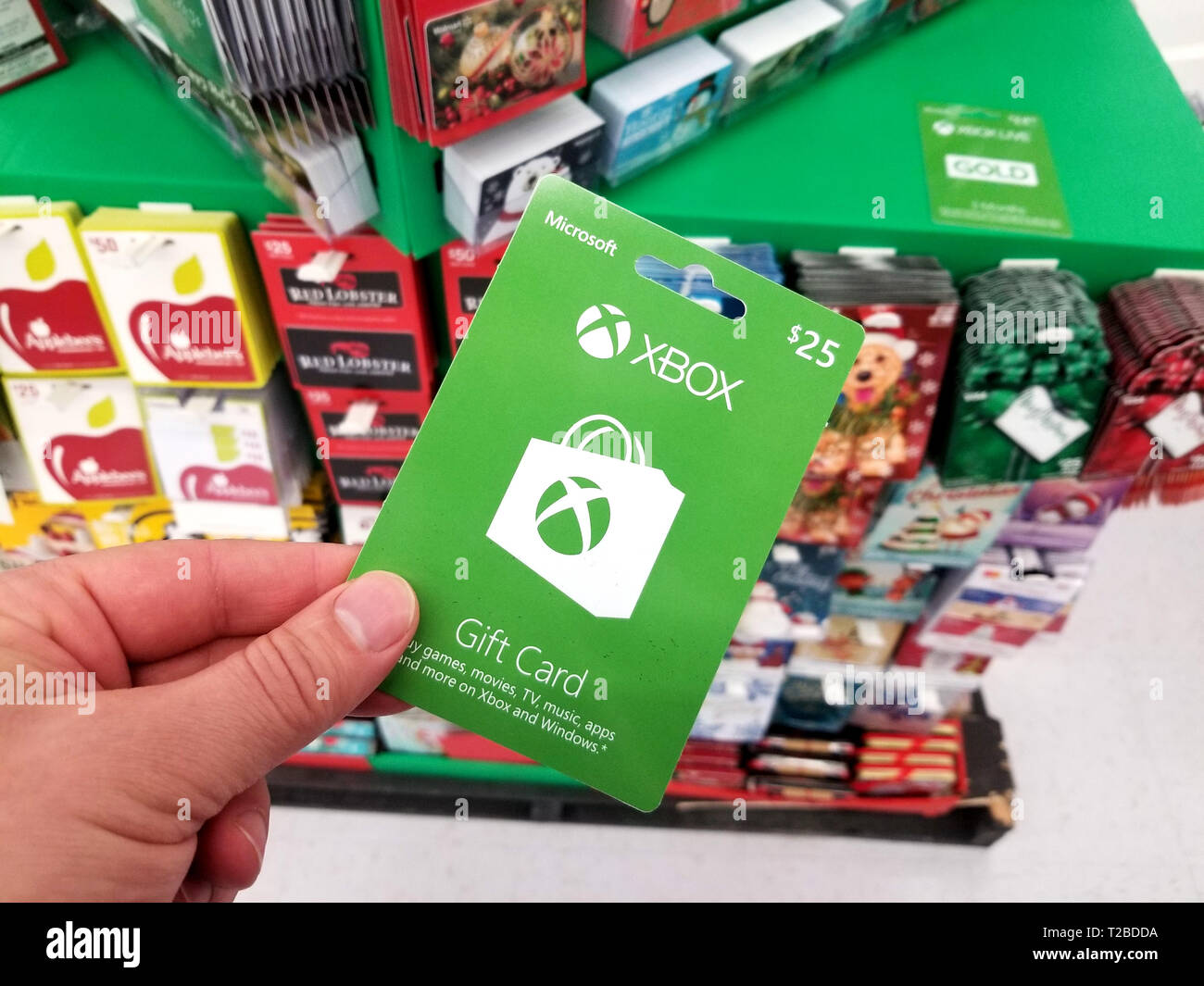 PLATTSBURGH, USA - Januar 21, 2019: Microsoft Xbox 25 dollar Geschenkkarte  in eine Hand über ein Regal mit verschiedenen Geschenkgutscheinen in einem  Walmart Stores. Xbox ist Stockfotografie - Alamy