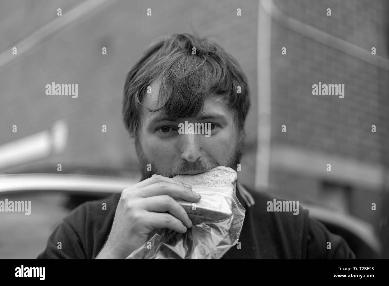 Ein Händler mit einem schmutzigen Gesicht frisst sein Mittagessen in Melbourne. Stockfoto