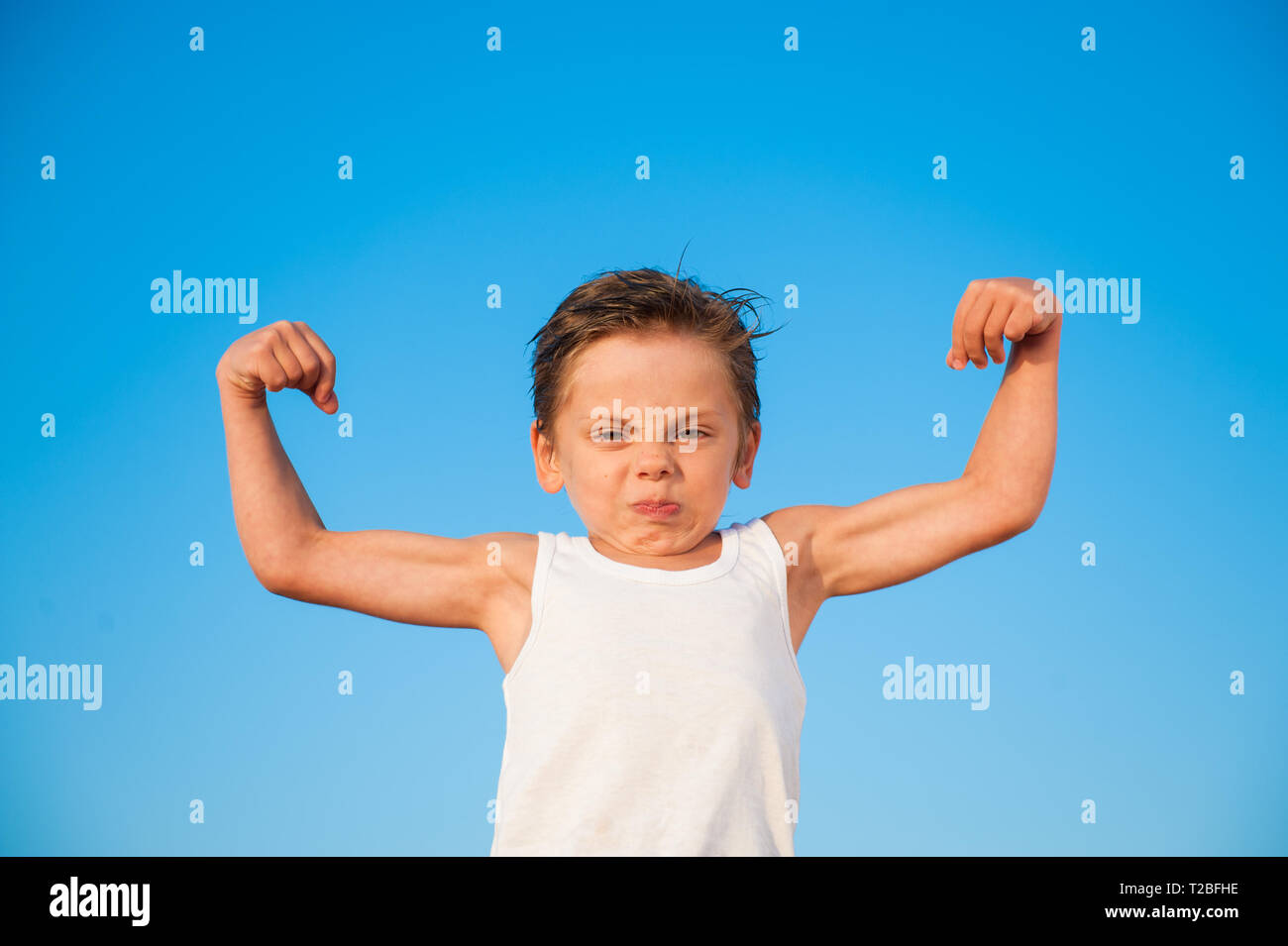 Cute aggressive kleine Zicklein in weißes Tank Top mit Muskel Bizeps auf blauen Himmel Hintergrund Stockfoto