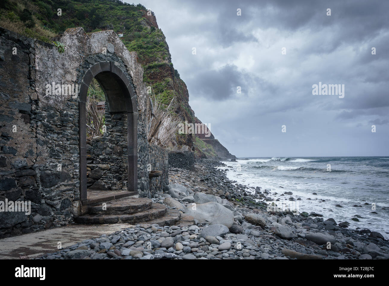 Ein verlorener Ort auf Madeira Sao Jorge, Portugal. Ein alter Hafen mit einer offenen Tür zum Ozean, an einem steinigen Strand. Sieht sehr geheimnisvolle Stockfoto
