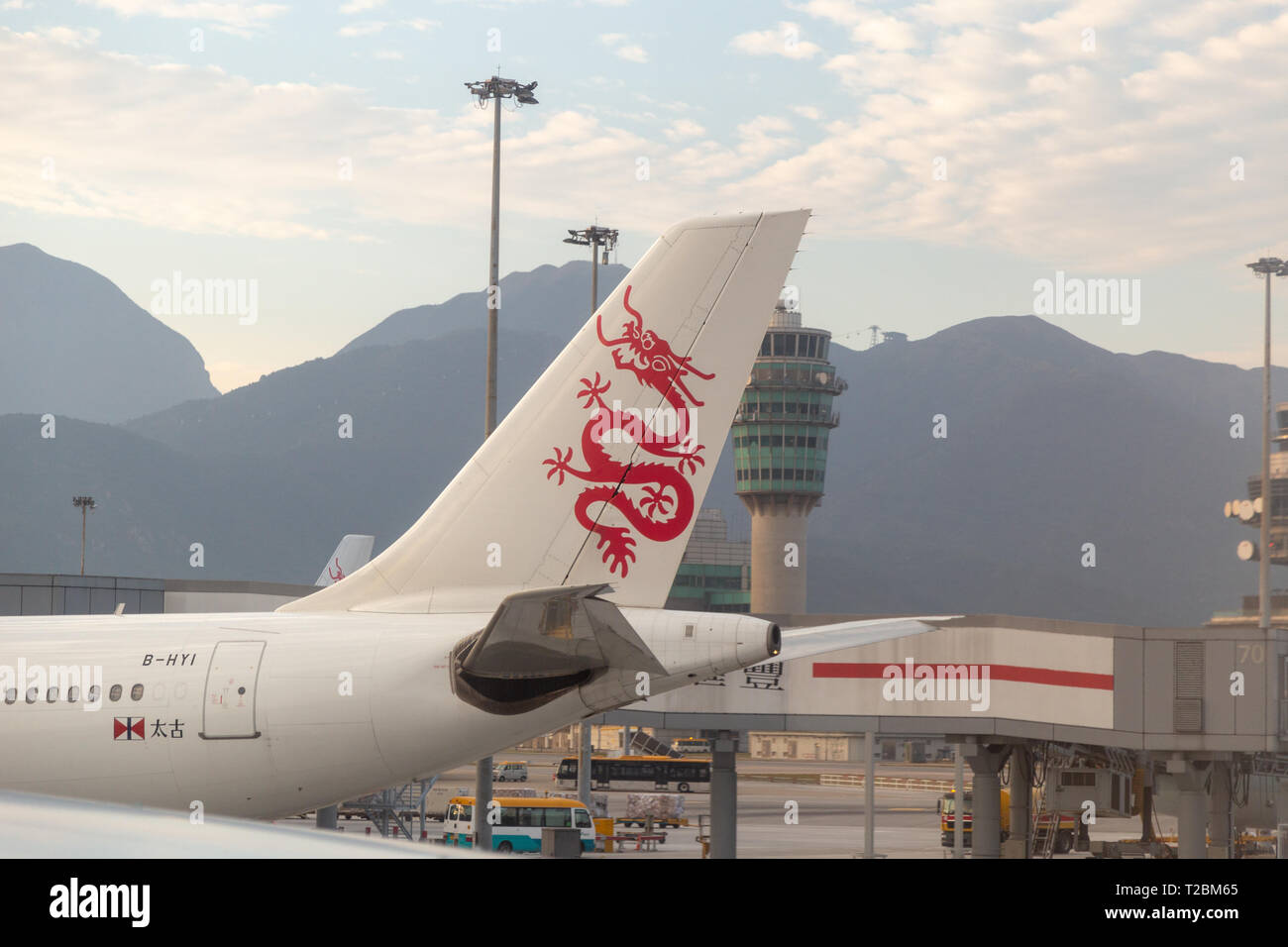 Cathay Dragon (Dragon Air) im Flughafen mit Air Traffic Control Tower im Hintergrund angedockt Stockfoto