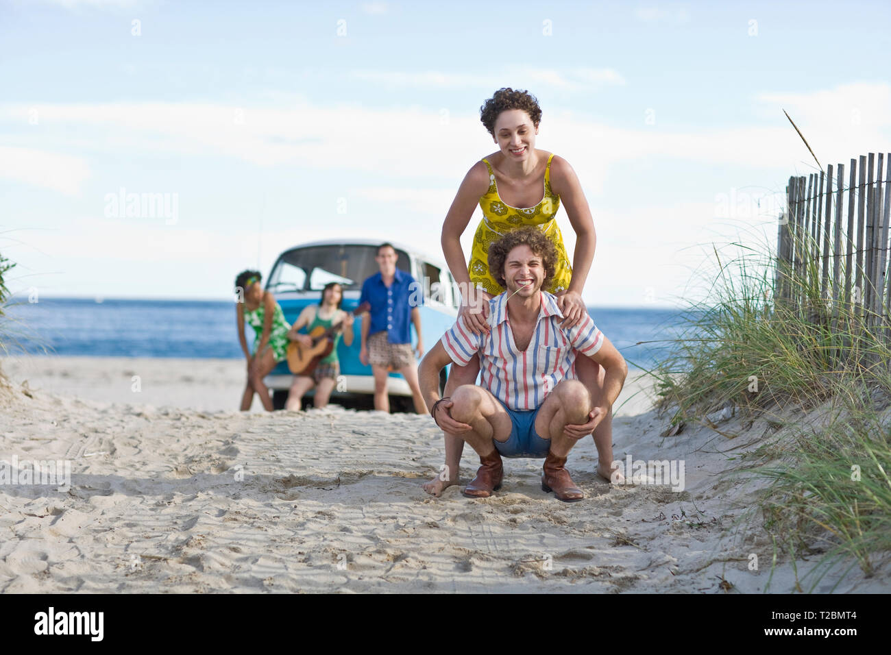 Porträt von einem jungen Paar, das Spaß am Strand mit Freunden. Stockfoto