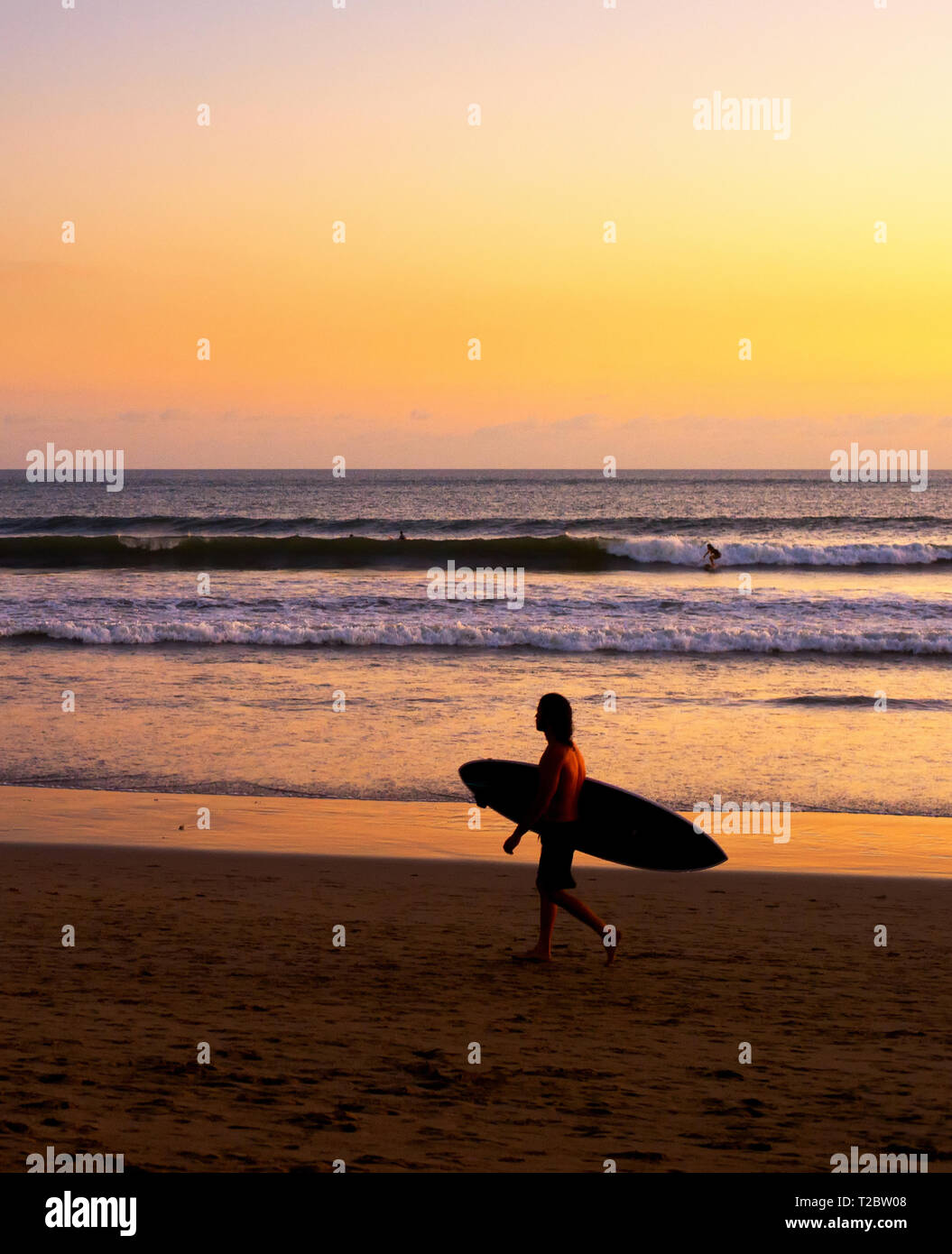 Am Strand Surfer am malerischen Sonnenuntergang, Bali, Indonesien Stockfoto