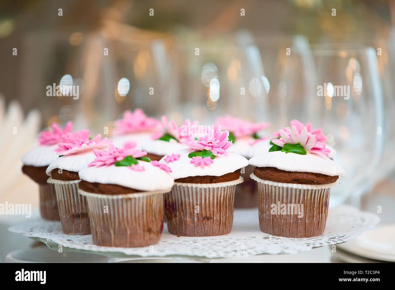 Kuchen für ein Buffet. Eine Gruppe von kleinen Cupcakes mit rosa Creme Blumen geschmückt. Stockfoto