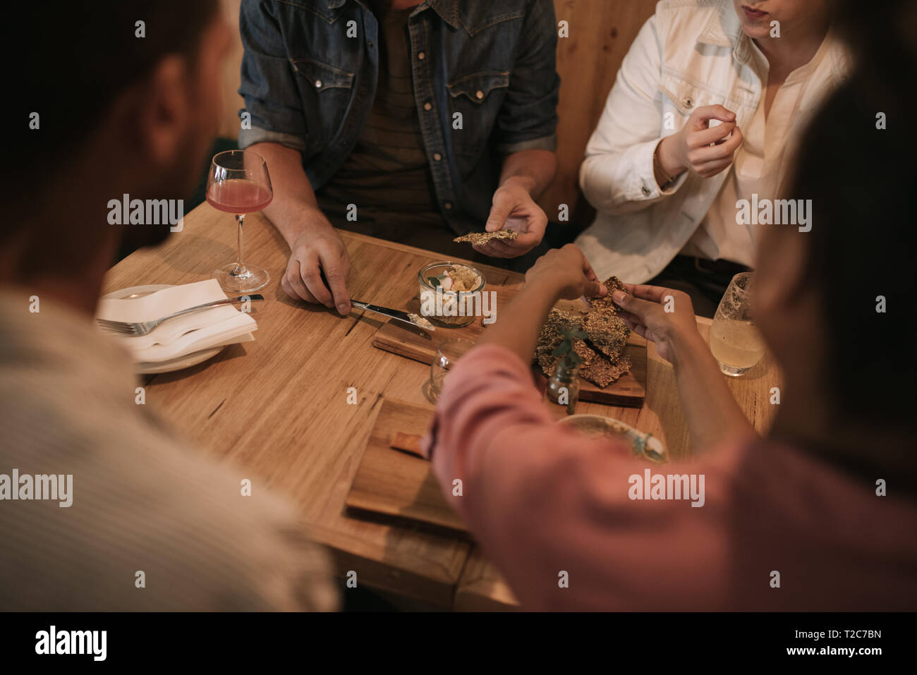 Vielfältige Gruppe von jungen Freunden zusammen sitzen an einem Tisch in einer angesagten Bar teilen Platten von Lebensmitteln Stockfoto