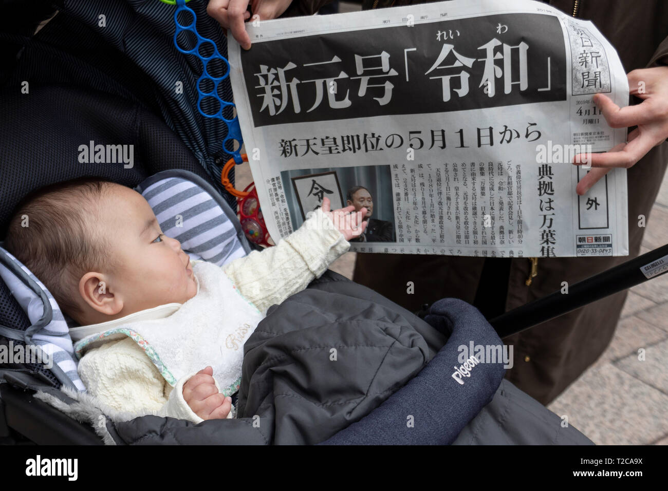 Tokio, Japan. 1 Apr, 2019. Tokio, Japan. 01 Apr, 2019. Ein Baby wird dargestellt, neben eine zusätzliche Ausgabe einer japanischen Zeitung Die kanji''Reiwa'' Ankündigung als neuen Namen der nächsten Kaiserzeit, in der Innenstadt von Tokio. Die japanische Chief Cabinet Secretary Yoshihide Suga angekündigt ''Reiwa'' als neue Kaiserzeit Name heute, 1. April. Die neue Ära beginnt am 1.Mai, wenn der Kronprinz Naruhito besteigt den Thron, nachdem sein Vater, Kaiser Akihito, formal dankt am 30. April. Credit: Rodrigo Reyes Marin/LBA/Alamy leben Nachrichten Stockfoto