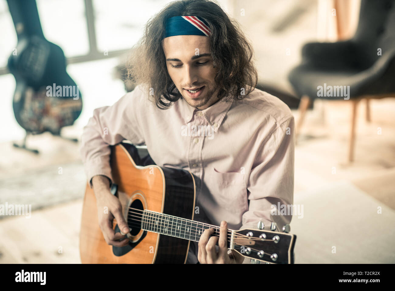 Gut aussehende junge Sängerin in hellen Bandana in musikalische Hobby Stockfoto
