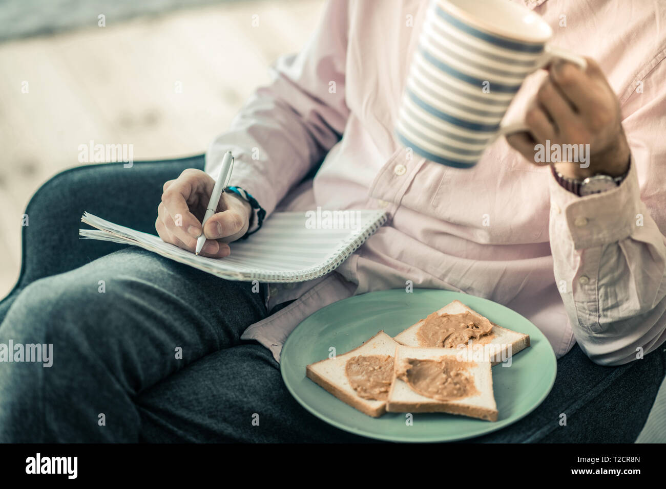 Kerl in Light Shirt Neue Zusammensetzung und Tee trinken. Stockfoto