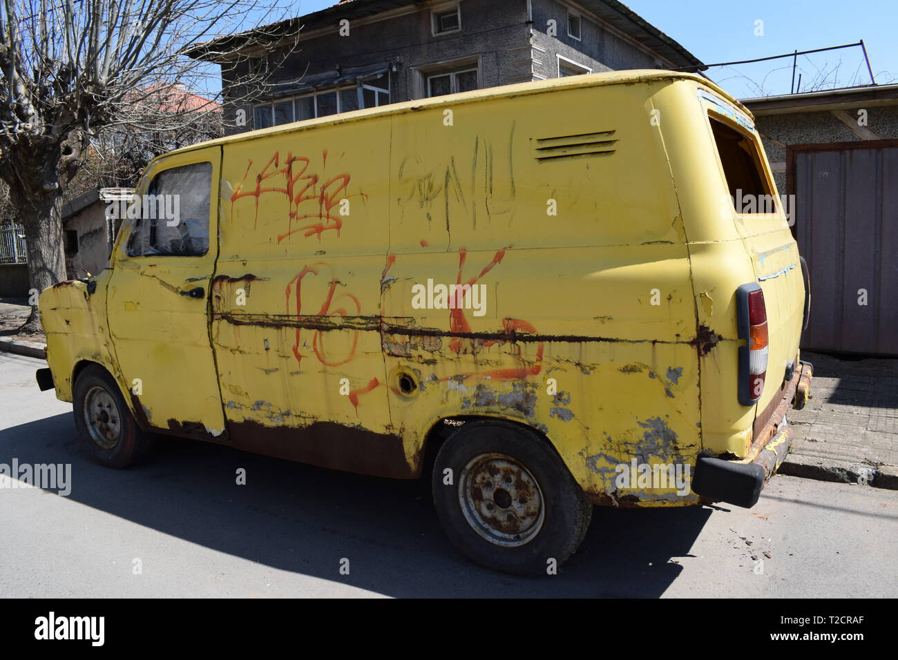 Eine gelbe Retro alten Bus mit Graffiti bemahlt und Rost im Überfluss auf der Straße Stockfoto