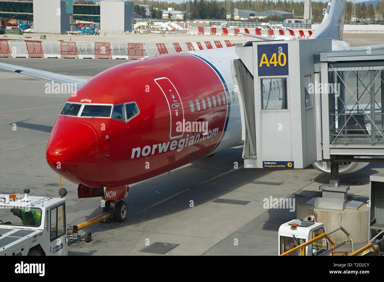 OSLO, Norwegen - 3. Mai 2015: Flugzeug von Norwegian Air Shuttle am Flughafen Oslo Gardermoen, levaing der Jet Bridge. Durch towtruck geschoben, bereit für d Stockfoto