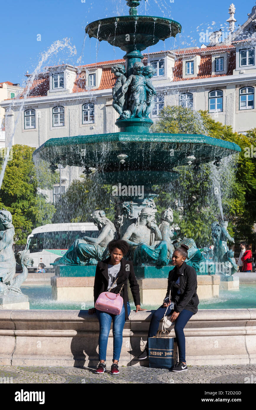 Zwei Mädchen sitzen durch die barocke Brunnen, Rossio Platz, Lissabon, Portugal Stockfoto