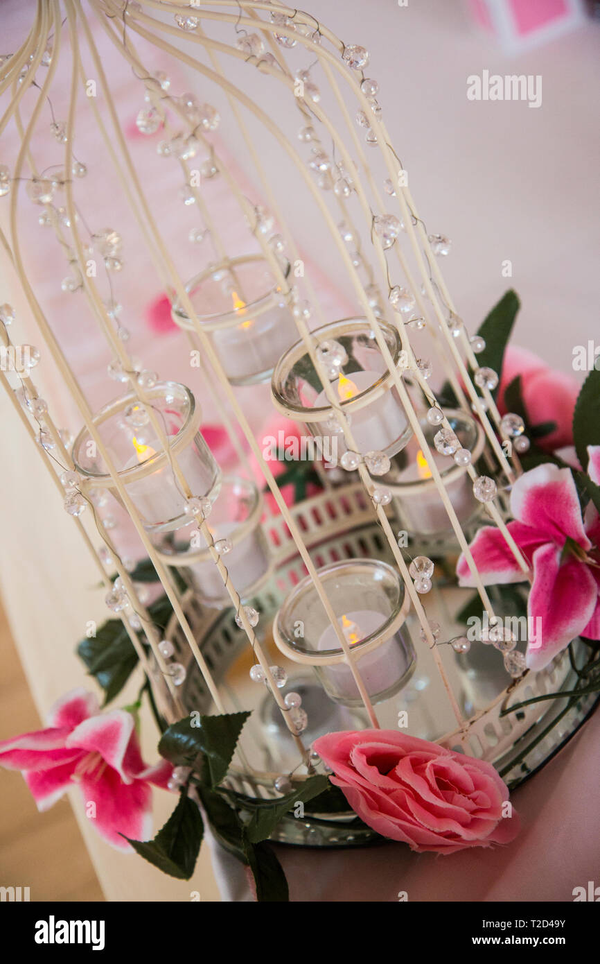 Vogelkäfig mit rosa Lilie Blumen auf einer Hochzeit Rezeption Tabelle auf einer Hochzeit in England eingerichtet Stockfoto