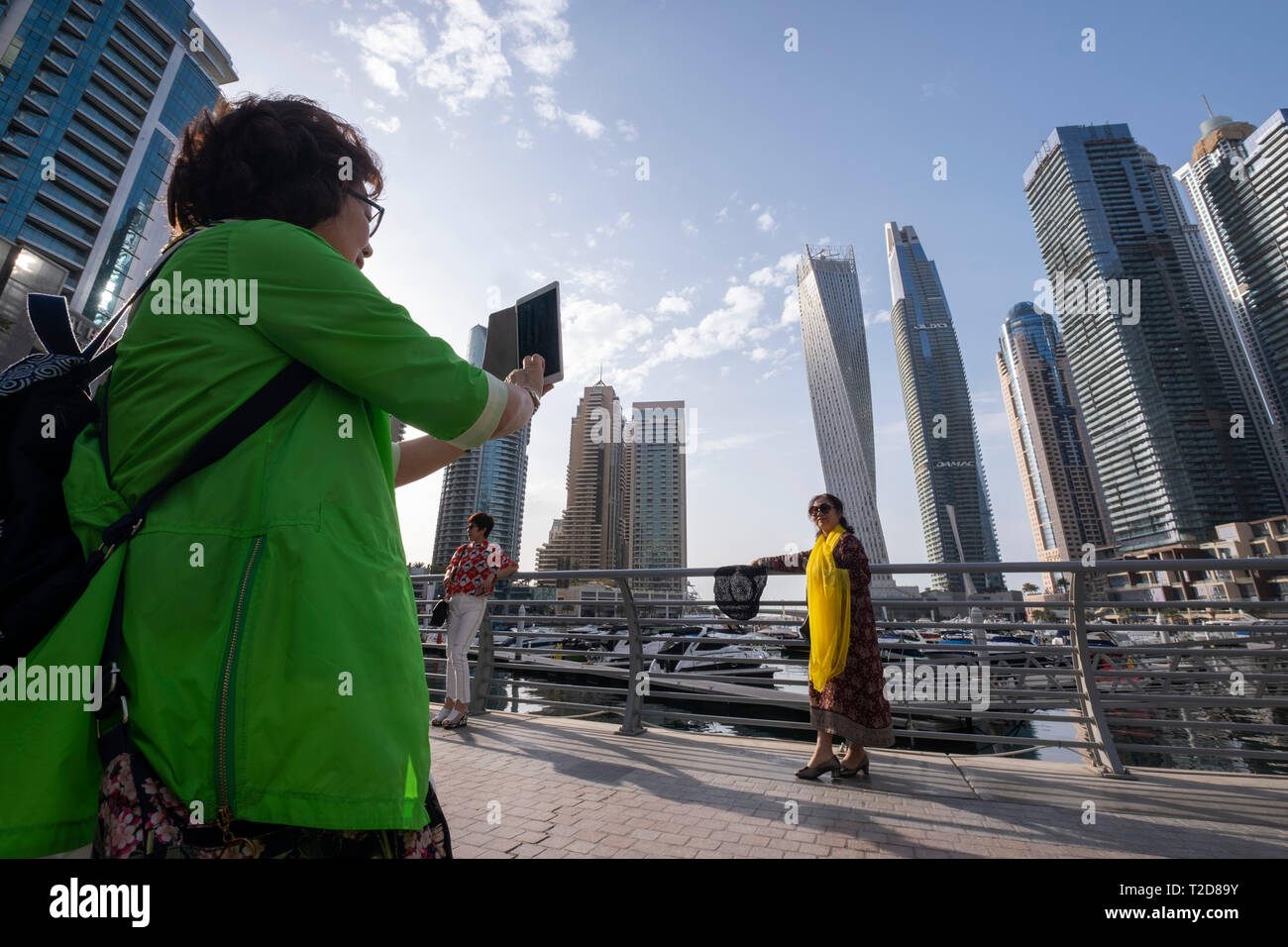 Asiatische Touristen für Fotografien in der Dubai Marina, Dubai, Vereinigte Arabische Emirate posing Stockfoto