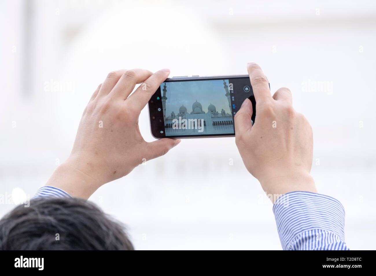 Tourist, Fotos mit einem Smartphone an der Sheikh Zayed Grand Moschee, Abu Dhabi, Vereinigte Arabische Emirate Stockfoto