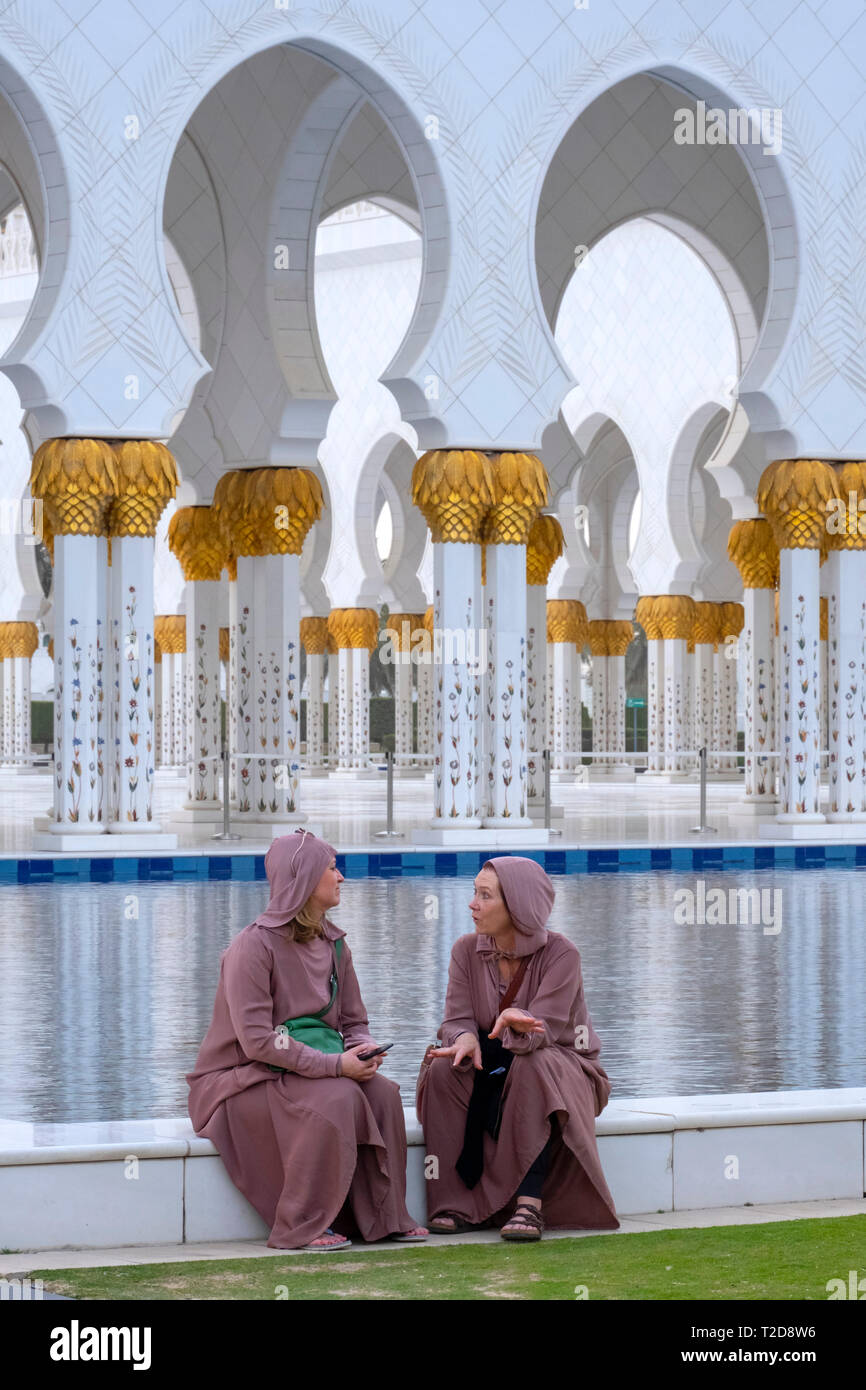 Zwei Frauen reden vor der Sheikh Zayed Grand Moschee, Abu Dhabi, Vereinigte Arabische Emirate Stockfoto
