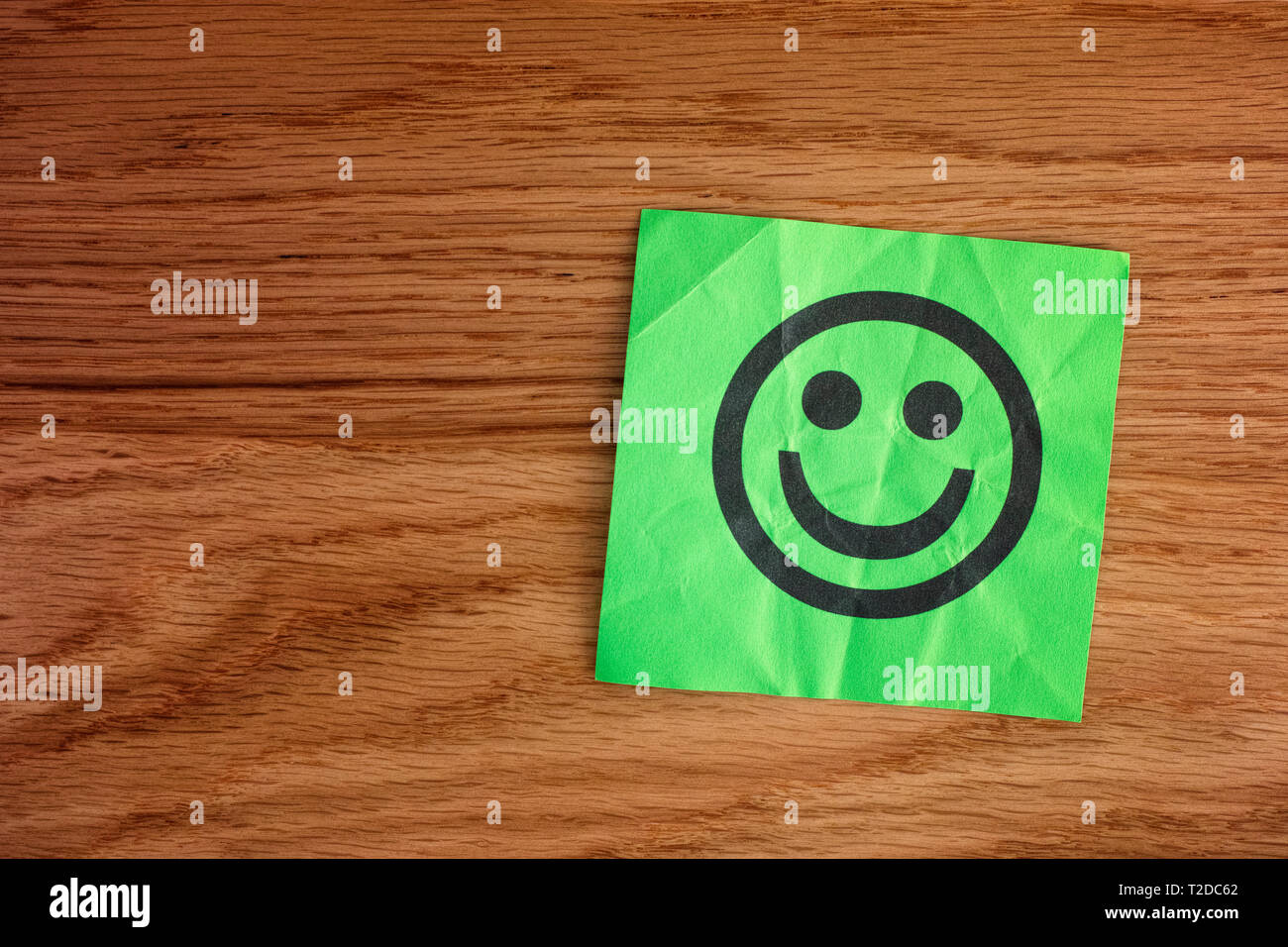 Papier mit glücklichen Gesicht auf Holz- Hintergrund. Close Up. Stockfoto